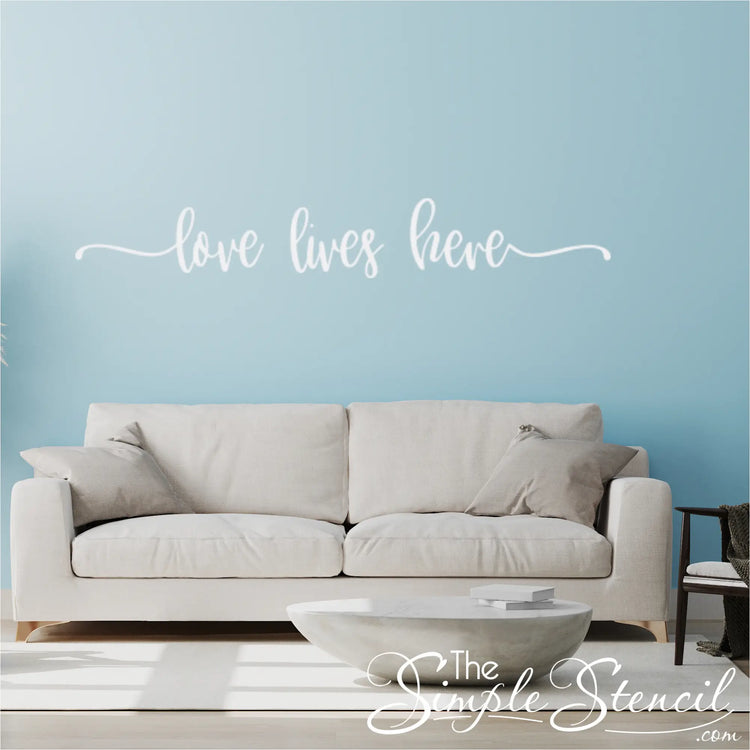 "Wall decal of 'Love Lives Here' in a family room, enhancing the welcoming feel of the home."