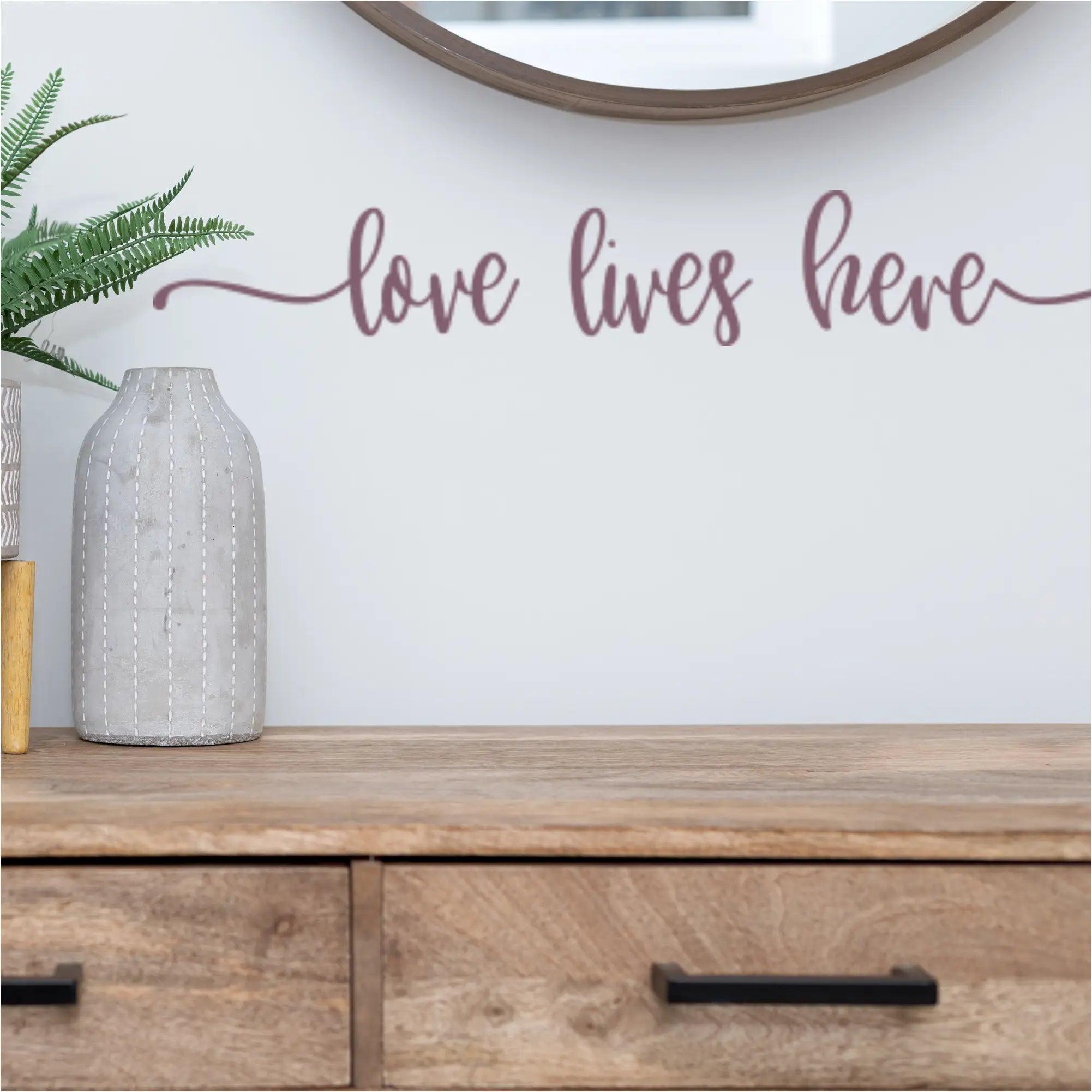 Wall decal with 'Love Lives Here' in a dining room, creating a warm atmosphere.