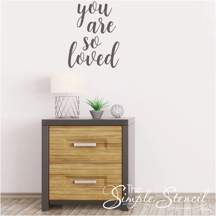 This "You are so loved" vinyl wall decal is just another way to express your love every single day to those you share your life with. Gray decal by The Simple Stencil on white wall. 