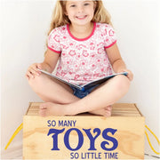 A cute vinyl decal that reads So many toys, so little time, installed on a box in a child's playroom