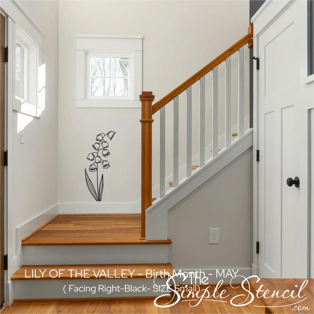 A black Lily of the Valley wall silhouette applied to a small white wall in a stairway landing for a subtle, illustrative home accent.
