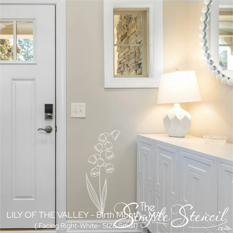 A white Lily of the Valley botanical silhouette applied to a beige entryway wall, welcoming guests with a fresh spring aesthetic.
