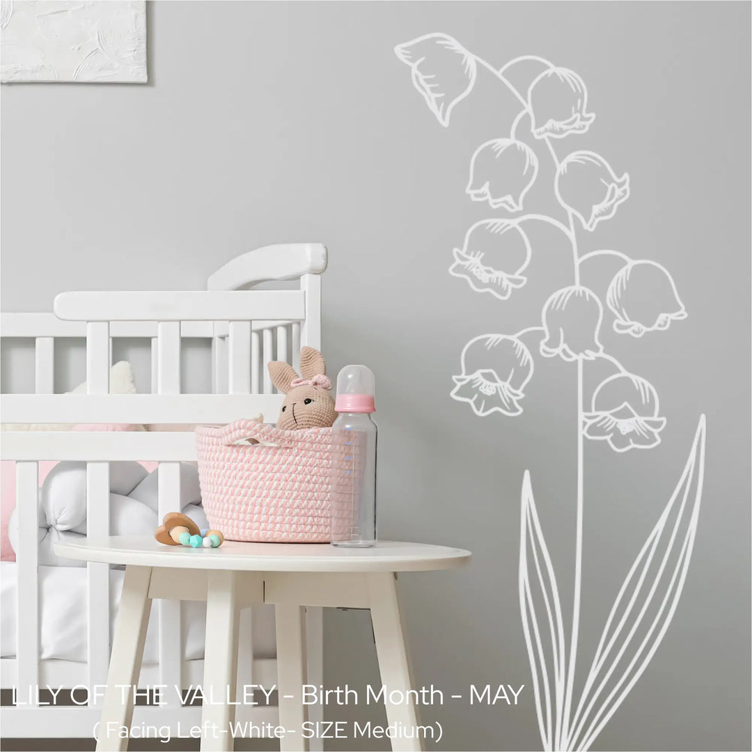 White Lily of the Valley wall silhouette applied to a soft grey nursery wall next to a white crib for a peaceful baby room vibe.