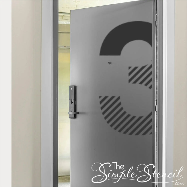 Modern black striped number 3 decal on a grey commercial office door shown slightly open for architectural context.