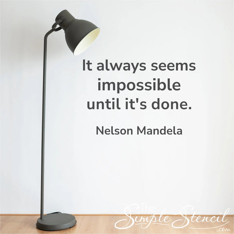 Black metal floor lamp with curved neck and adjustable head next to modern nelson mandela silhouette vinyl art decal