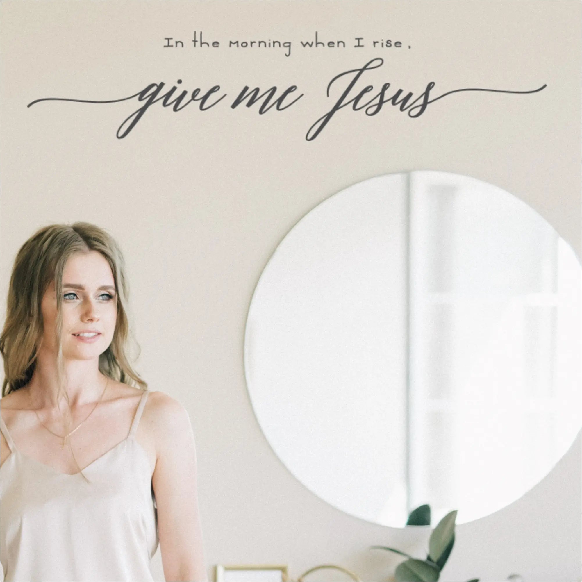 Close-up of a woman smiling peacefully as she reads the "In the morning when I rise, give me Jesus" wall decal in her bedroom. By The Simple Stencil