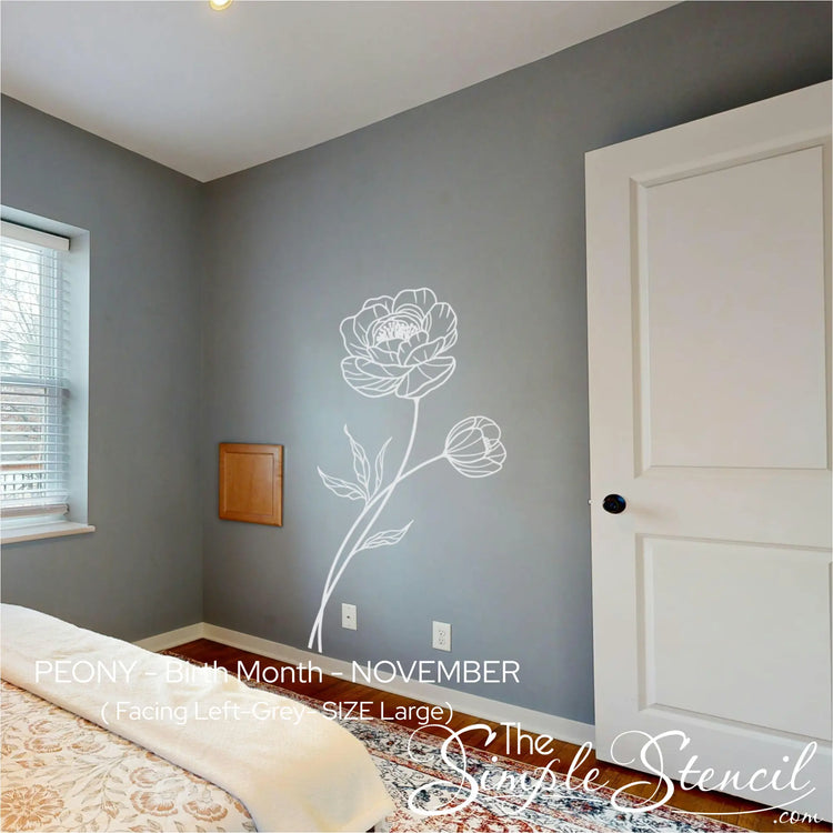 Room interior with a floral wall decal on a gray wall, featuring a bed and door.