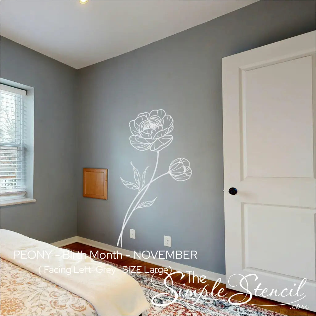 Room interior with a floral wall decal on a gray wall, featuring a bed and door.