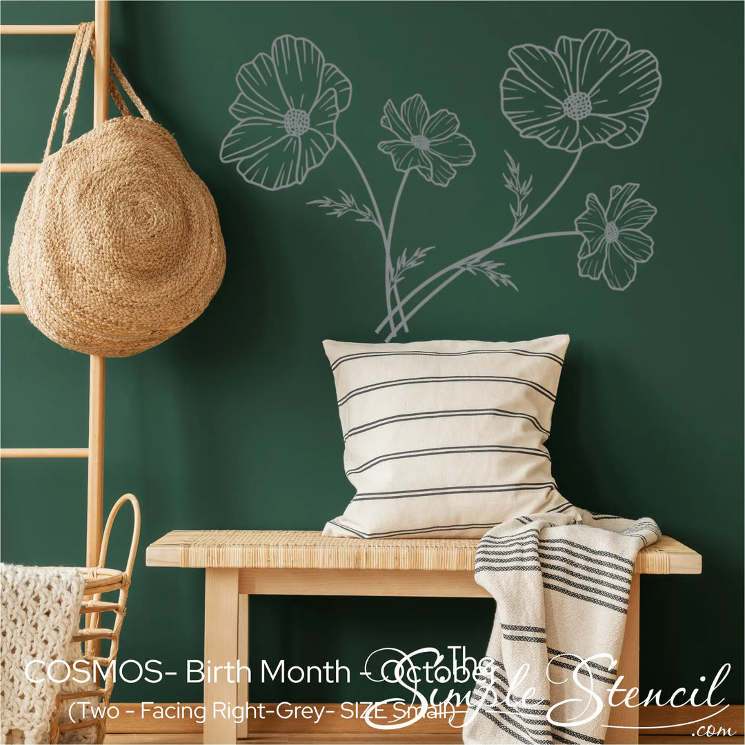A set of two grey Cosmos wall silhouettes applied to a dark forest green wall to create a custom botanical bouquet effect.
