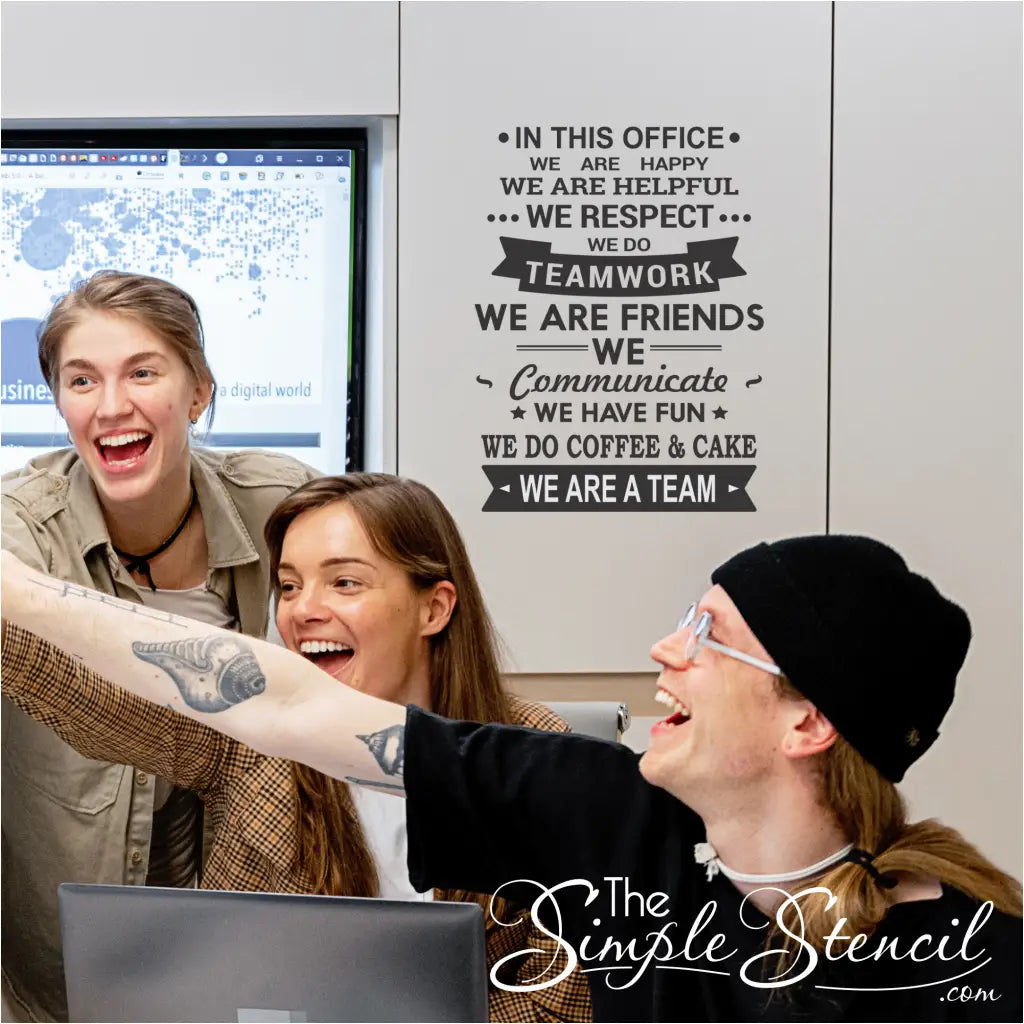 Image of the wall decor installed: "The wall decor mounted on a wall in an office setting, surrounded by happy employees."