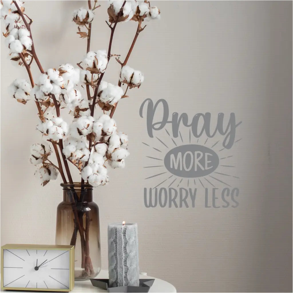 Wall decal with the quote "Pray More Worry Less" near bedside table in master bedroom