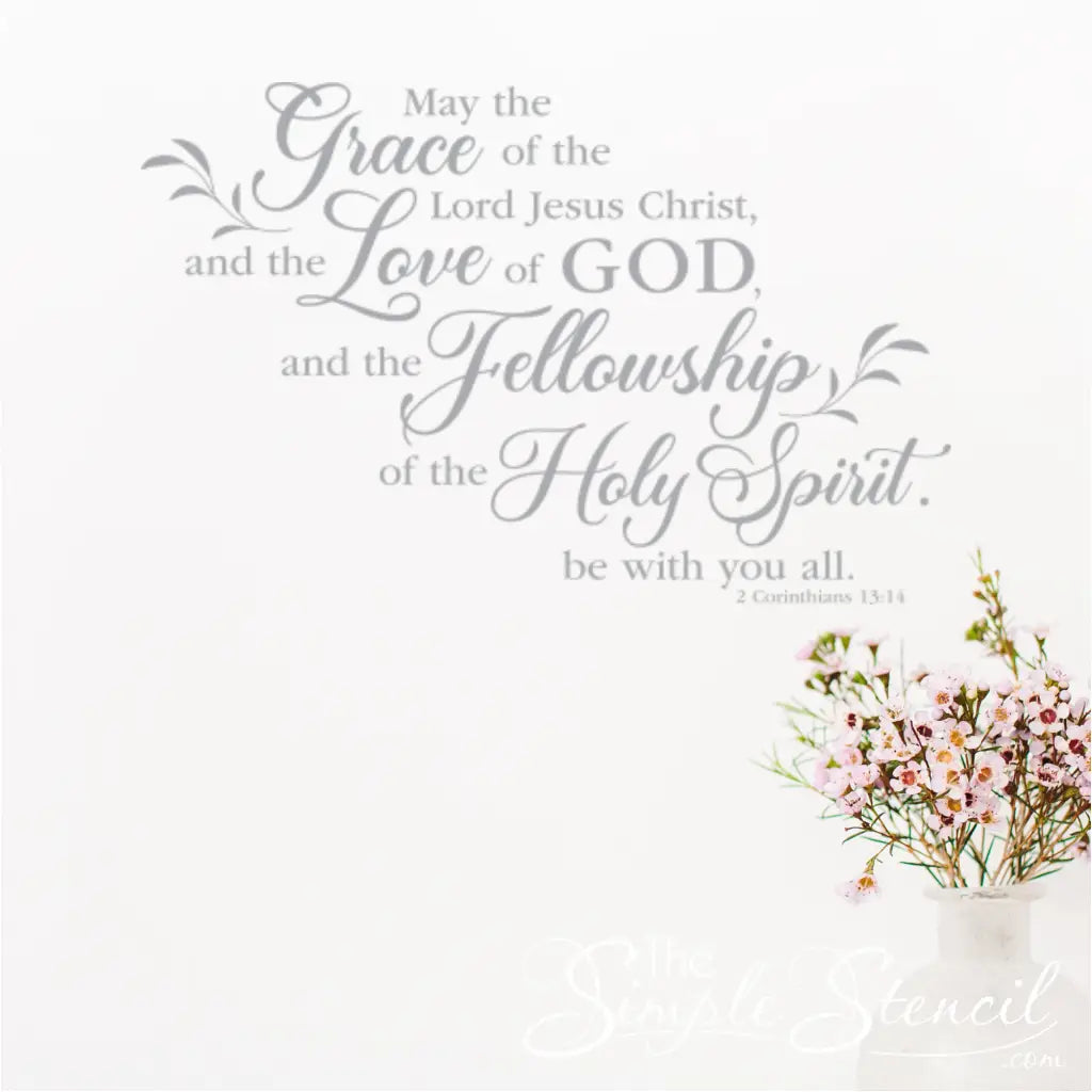 Light grey 2 Corinthians 13:14 decal on a white wall, featuring the words "Grace," "Love," and "Fellowship" next to a vase of light pink flowers.