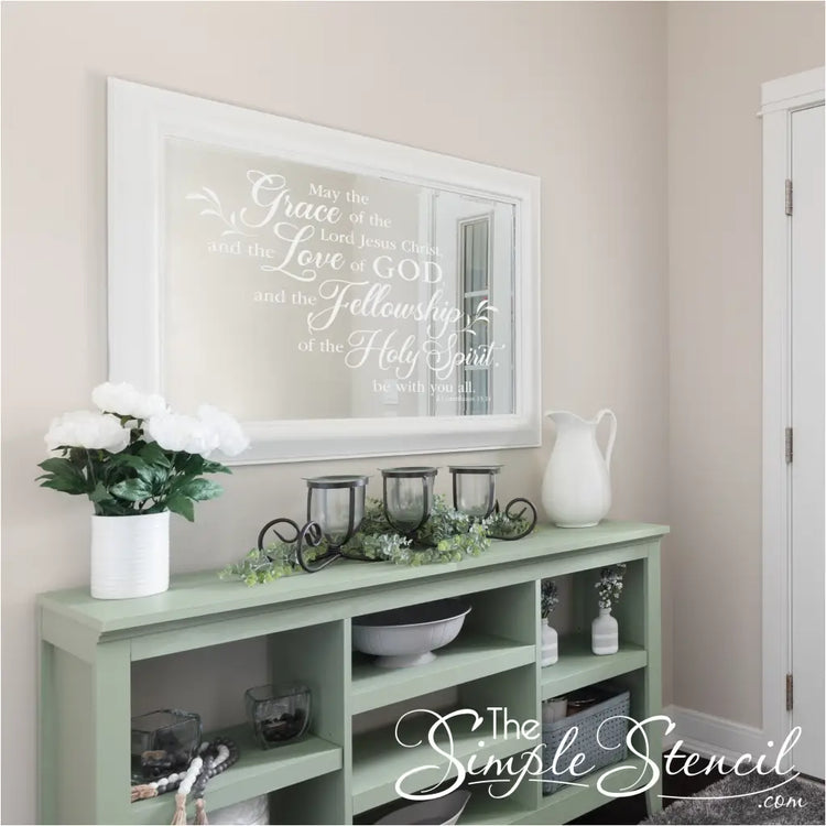 White 2 Corinthians 13:14 decal applied directly to a large white-framed mirror, placed above a green console table in a welcoming entry hall.