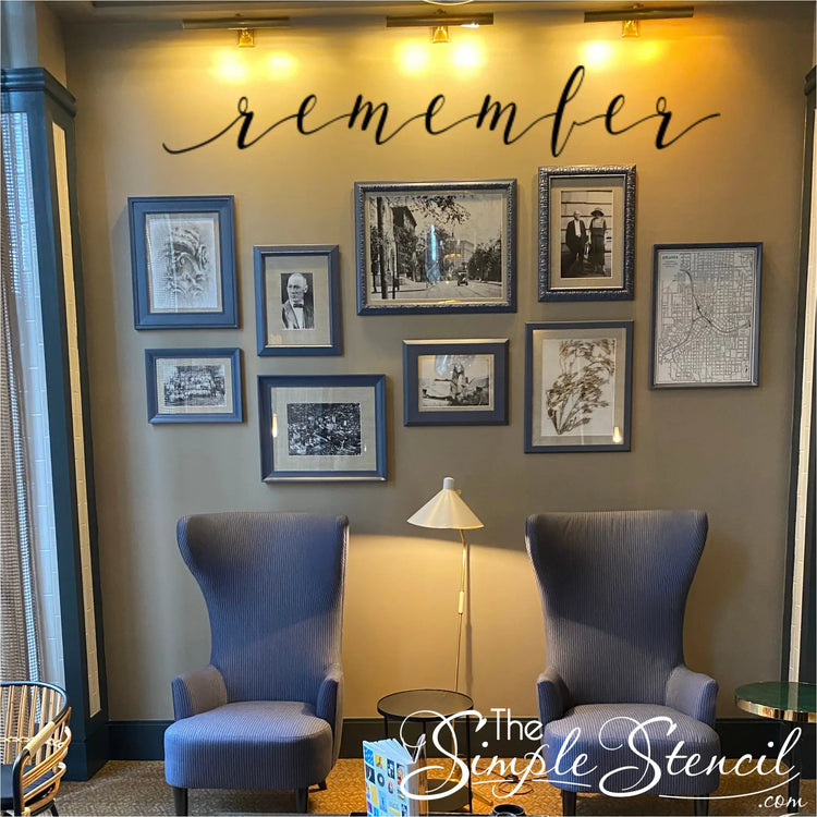 a beautiful family picture wall over a sitting area with the wall decal that reads simply remember to highlight their ancestors memories. 