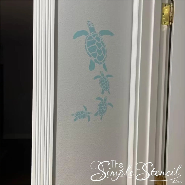 Coastal home decor: Self-adhesive wall art with a family of swimming sea turtles.
