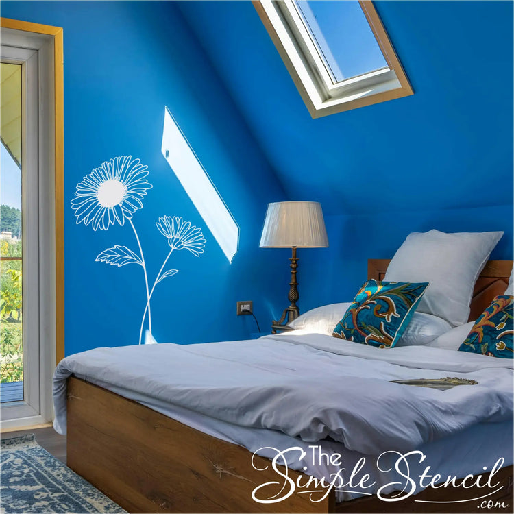 White Aster birth flower wall lettering applied to a bold blue bedroom wall under a skylight for a nature-inspired look.