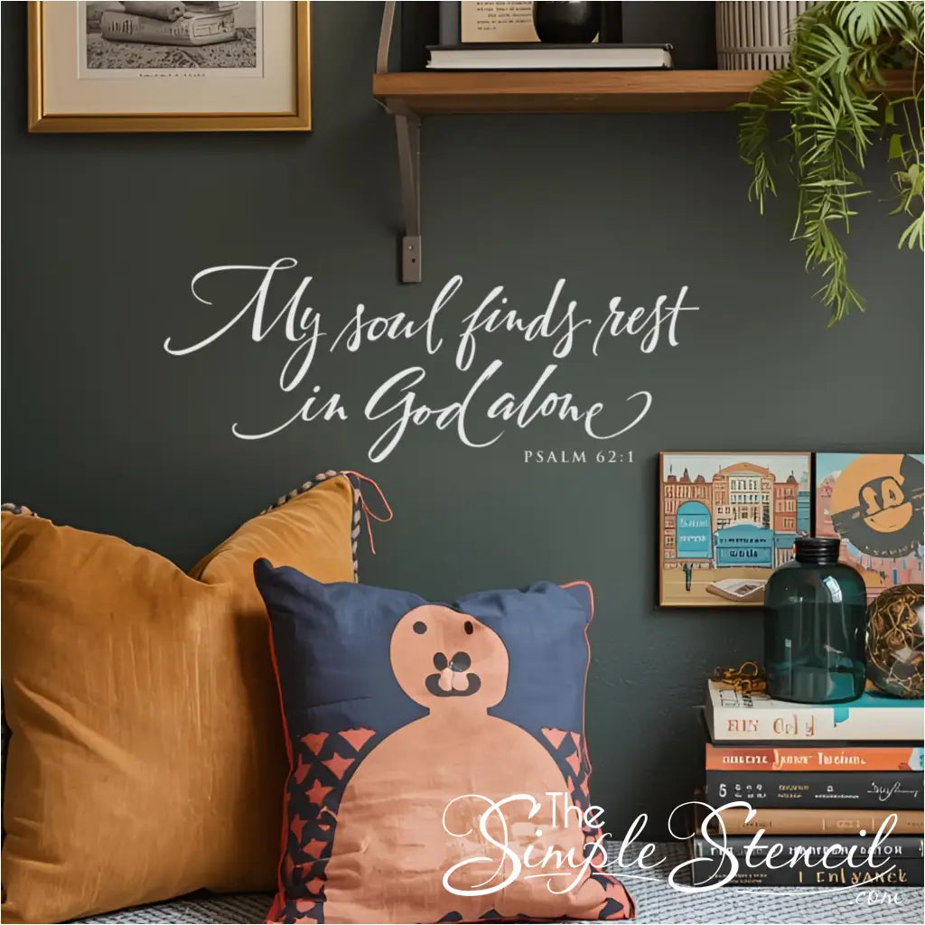 "My soul finds rest in God alone" white decal on a dark emerald green wall, styled with books and plants. 