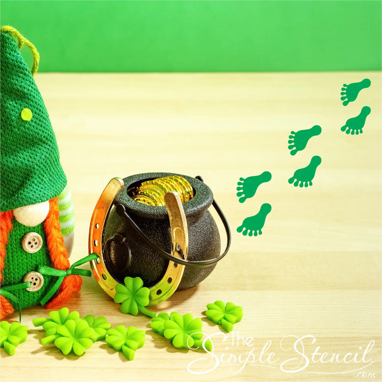 Black pot with gold coins and a horseshoe handle surrounded by shamrocks for patricks day leprechaun footprint decor