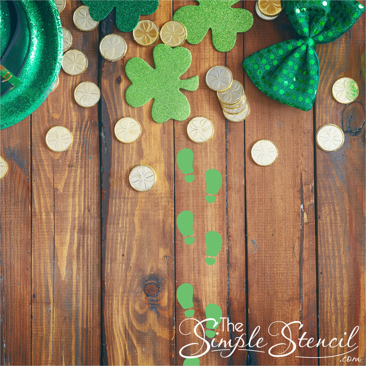 St patricks day leprechaun footprint decal sets with green glitter shamrocks and metallic gold coins on wood surface