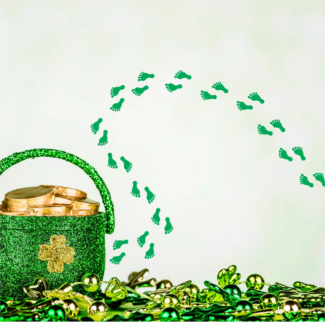 A glittery green pot with a gold shamrock filled with golden coins surrounded by patricks day leprechaun footprint decor