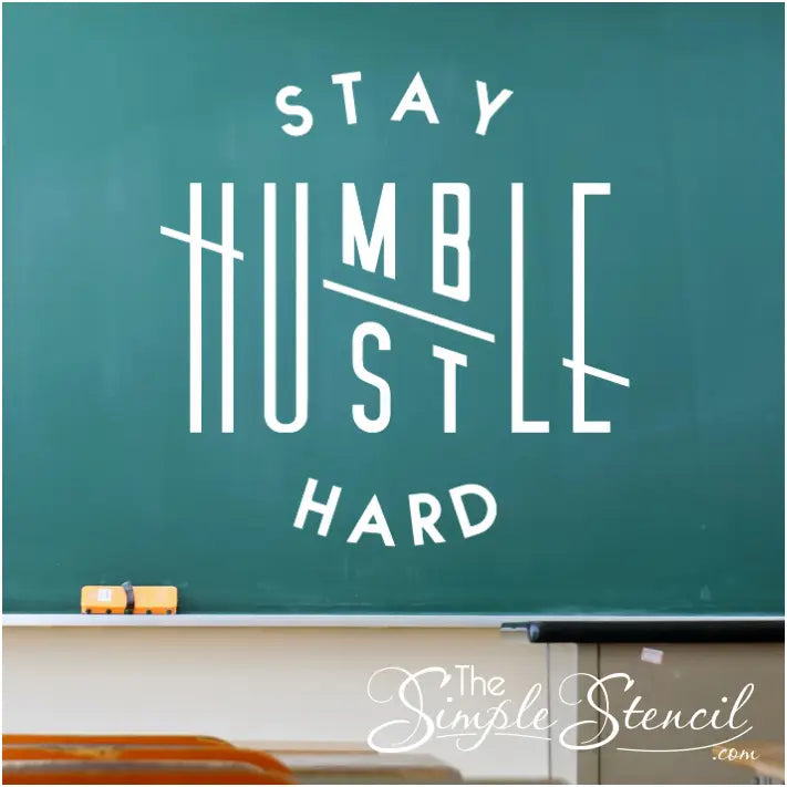 Stay Humble Hustle Hard creatively designed wall decal by The Simple Stencil  shown installed on a school classroom chalkboard.