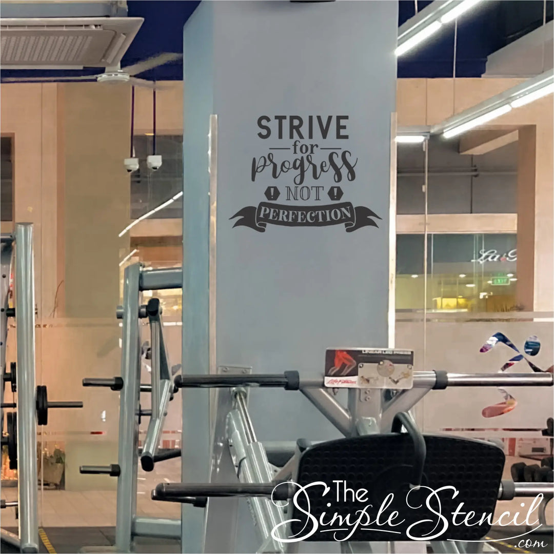 Gym equipment with motivational quote on a wall that reads: Strive for progress not perfection. 