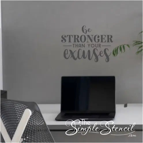A wall quote decal by TheSimpleStencil that reads Be Stronger Than Your Excuses placed over a home office desk.