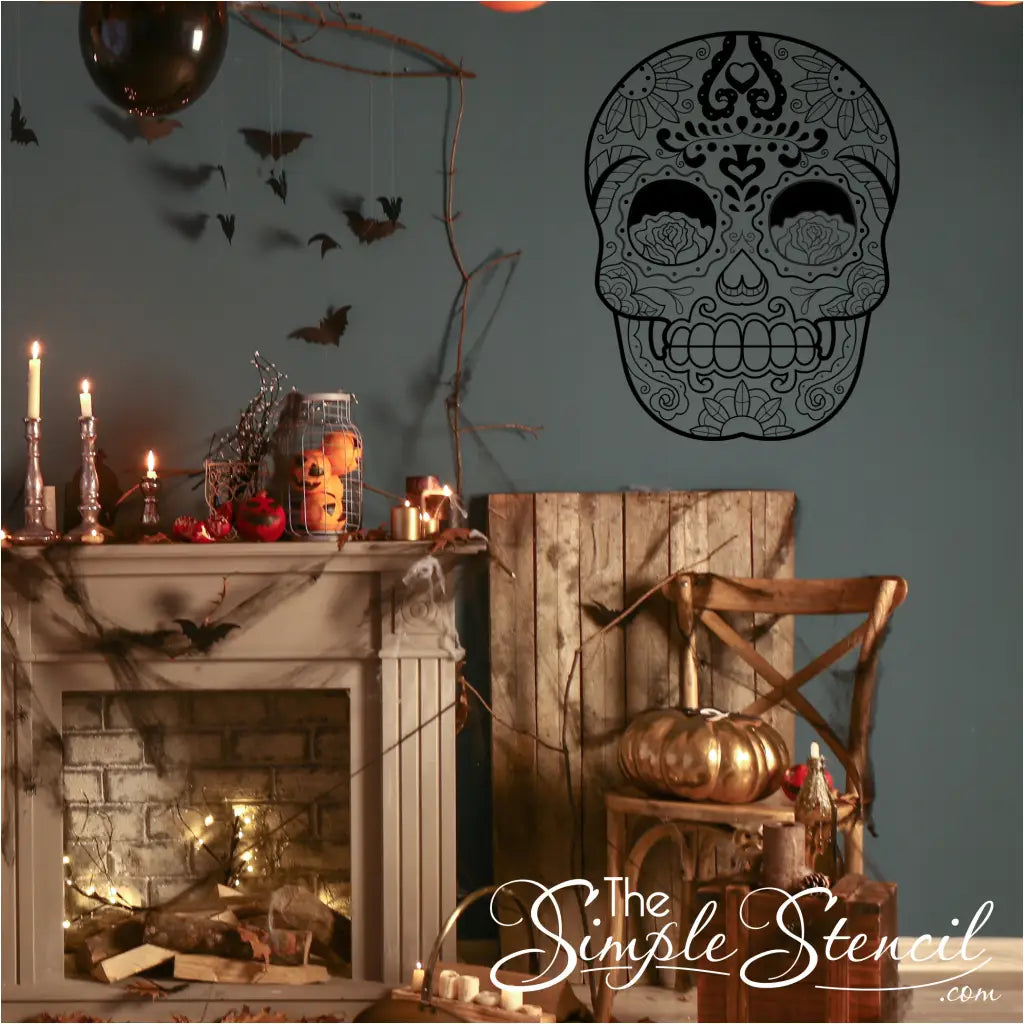 A black sugar skull vinyl wall decal on a dark blue wall, above a beautifully decorated Halloween fireplace and sitting chair.

Shown in size 28.5" x 37 in matte black by The Simple Stencil