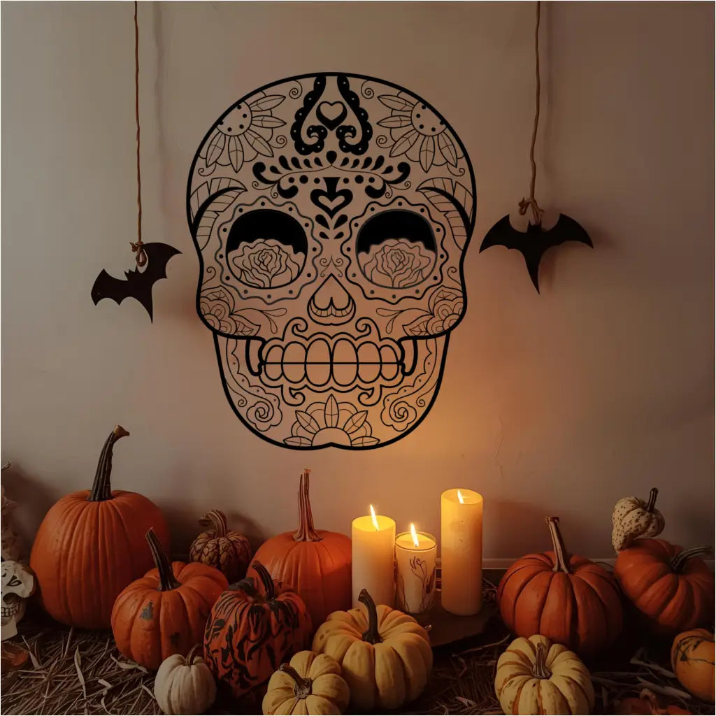 A black sugar skull vinyl wall decal displayed above a festive arrangement of pumpkins and candles for Halloween. - Size 22 x 28.5 in Matte Black by The Simple Stencil