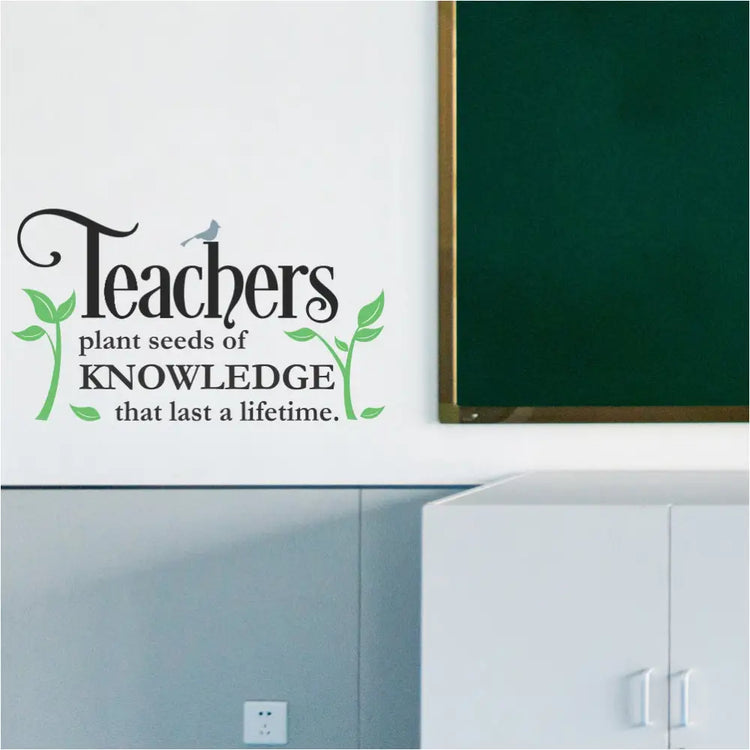  A colorful "Teachers Plant Seeds" inspirational wall decal displayed on a bright teacher's lounge wall with comfortable chairs. The plants, bird, and text are all in different colors to showcase customization options.