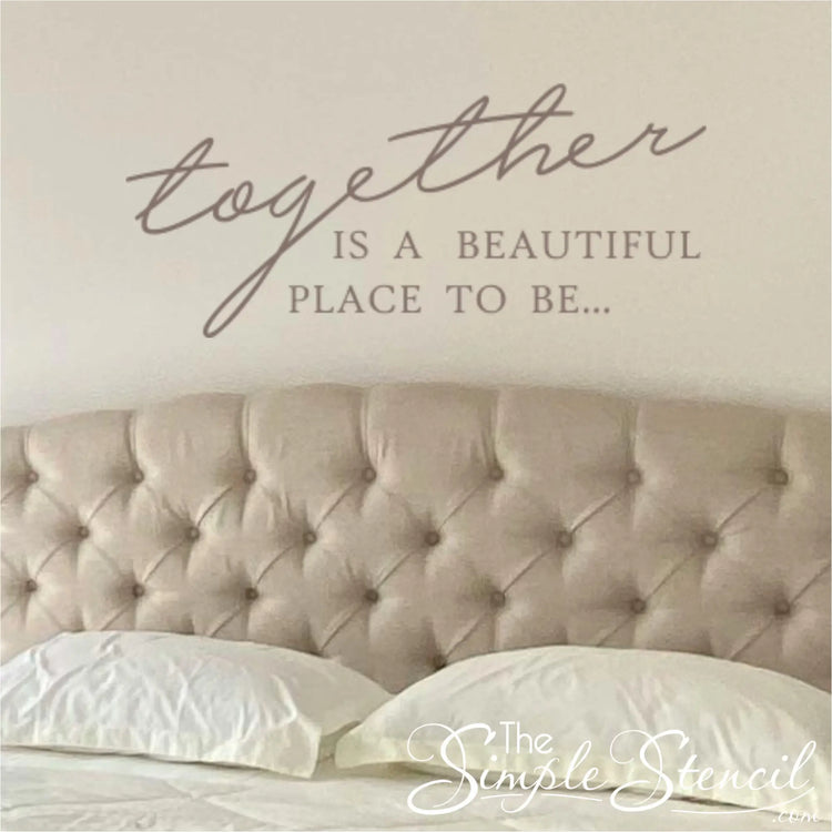 Close-up of a taupe romantic wall decal applied above a tufted beige headboard, showing how the decal transforms a master bedroom suite with elegant typography.