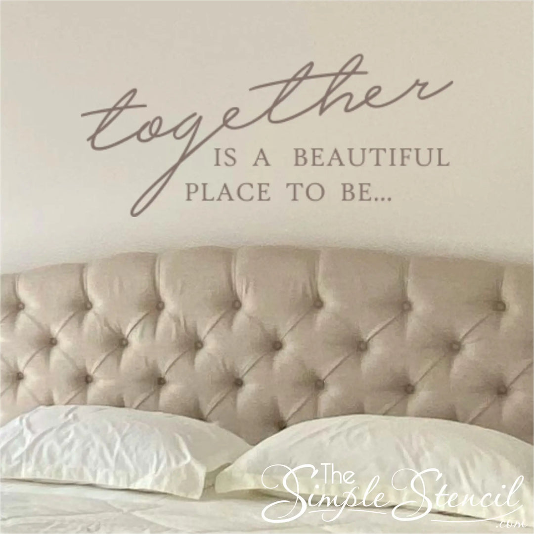 Close-up of a taupe romantic wall decal applied above a tufted beige headboard, showing how the decal transforms a master bedroom suite with elegant typography.