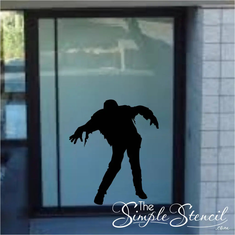 Walking zombie applied to a glass door front appears to be lurking towards trick or treaters during Halloween parties or Haunted House admissions. The Simple Stencil Halloween Decals