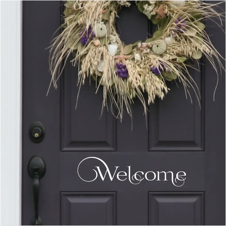 Welcome Decal in a swirly pattern installed on a black door using white vinyl decal transfer by The Simple Stencil. So easy to install and it&