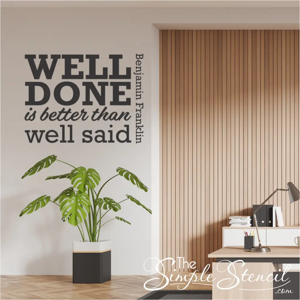 "Well Done is Better Than Well Said" wall decal applied above a desk.