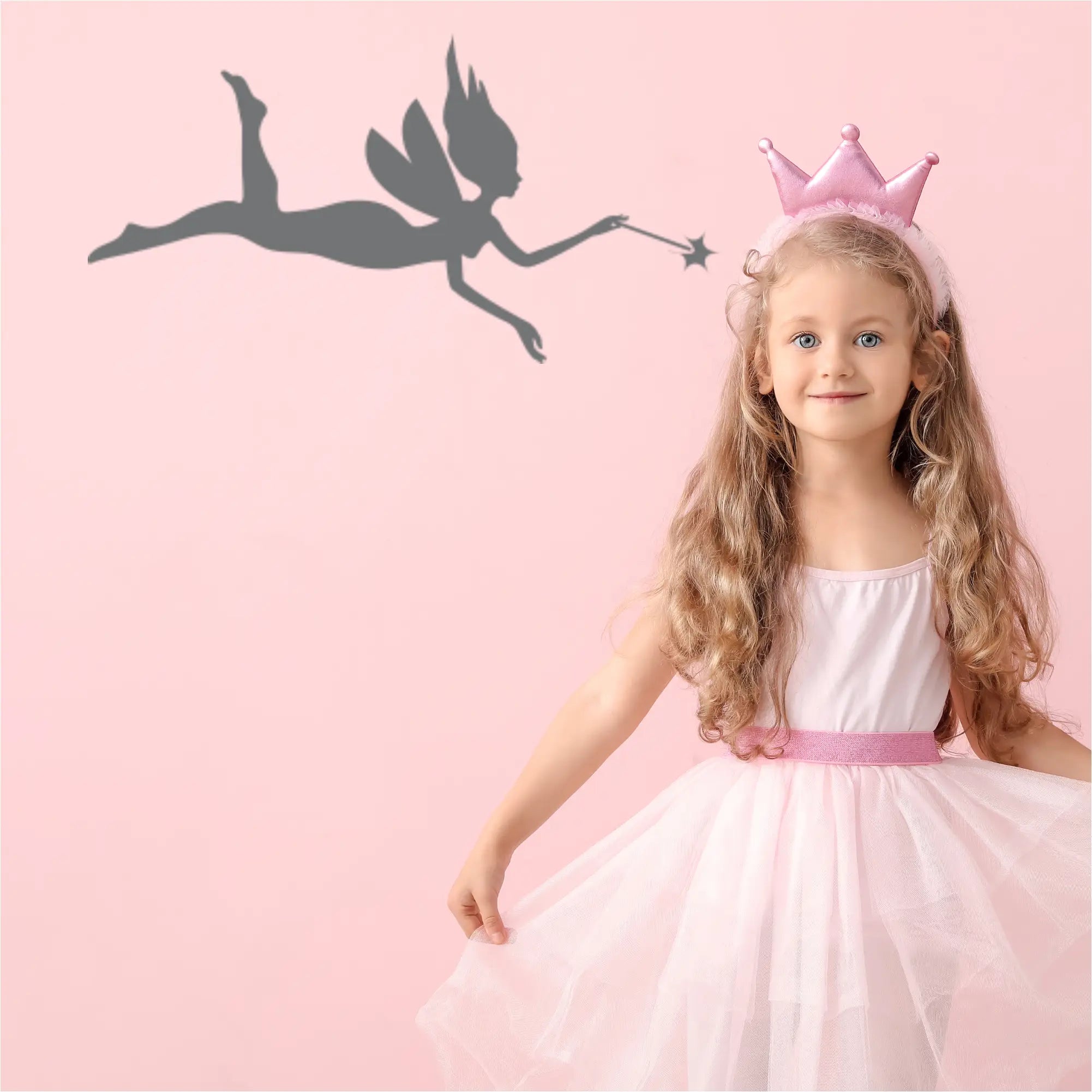 Whimsical fairy decal applied to a pink wall in a little girl's magical bedroom.