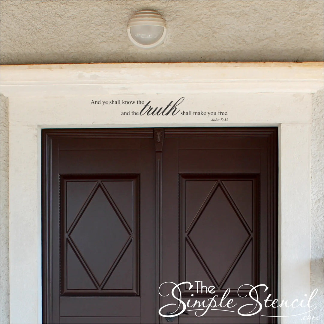 Scripture wall lettering applied above a dark brown exterior-style double door, showcasing how the John 8:32 decal adds a spiritual touch to home architecture.