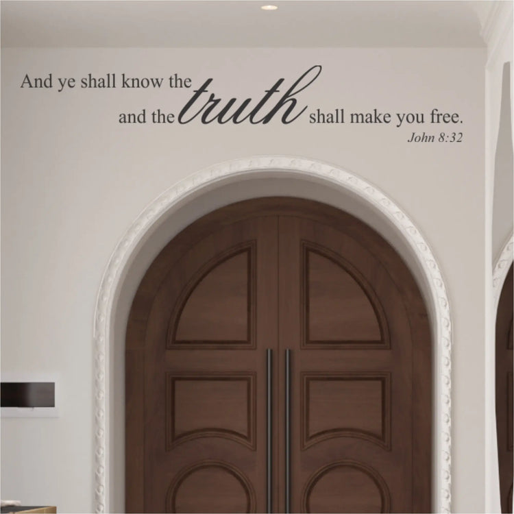 John 8:32 scripture wall decal displayed in dark charcoal vinyl above a large, arched wooden church doorway, creating a professional and welcoming sanctuary entrance.